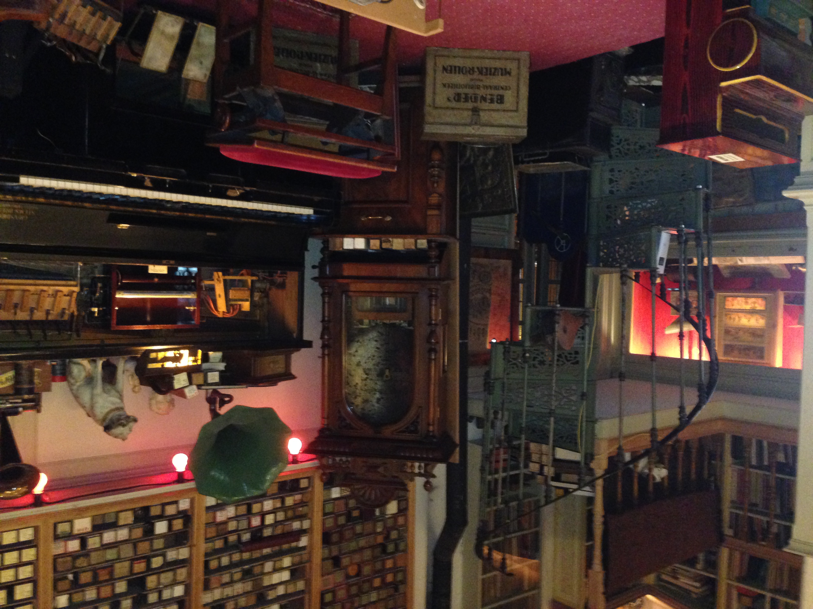 Interior of Amsterdam’s Pianola Museum with player pianos, piano rolls and mechanical music equipment displayed closely together.